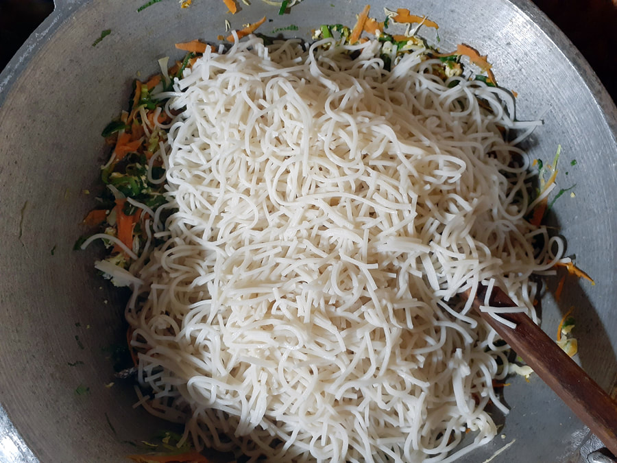 boiled rice noodles on the wok with vegetables